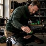 Man applying ceramic coating on car hood indoors