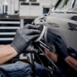 Hands applying polish to car paint