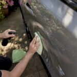 Hands applying waterless car wash product