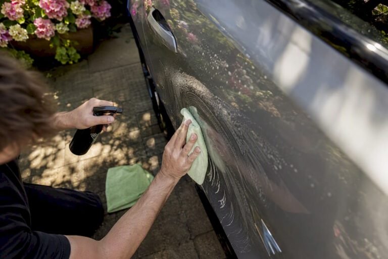 Hands applying waterless car wash product