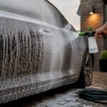 Garden hose applying foam to car paint