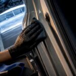 Hand cleaning an anonymous car door jamb