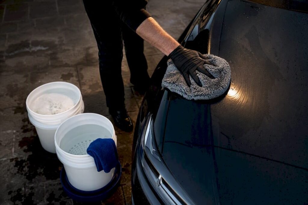 Two bucket wash beside glossy paint panel