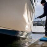 Technician rinsing a clean gelcoat hull