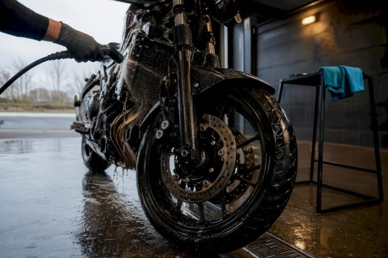 Rider rinsing motorcycle after wet ride