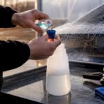 Hands measuring snow foam solution outdoors