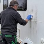 Owner removing black streaks from caravan