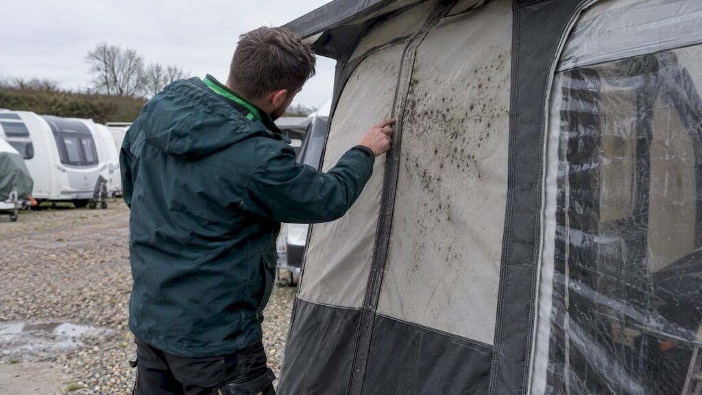Technician checking mould on caravan awning