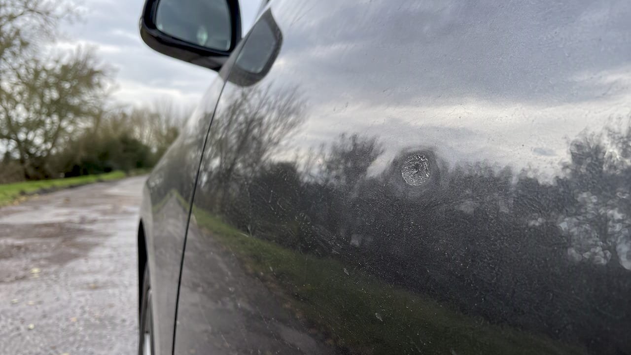 Dull crater-like etching visible in clean car paint