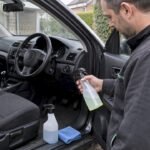 Car owner choosing a cleaner beside cabin surfaces