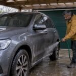 Owner rinsing winter road salt from car